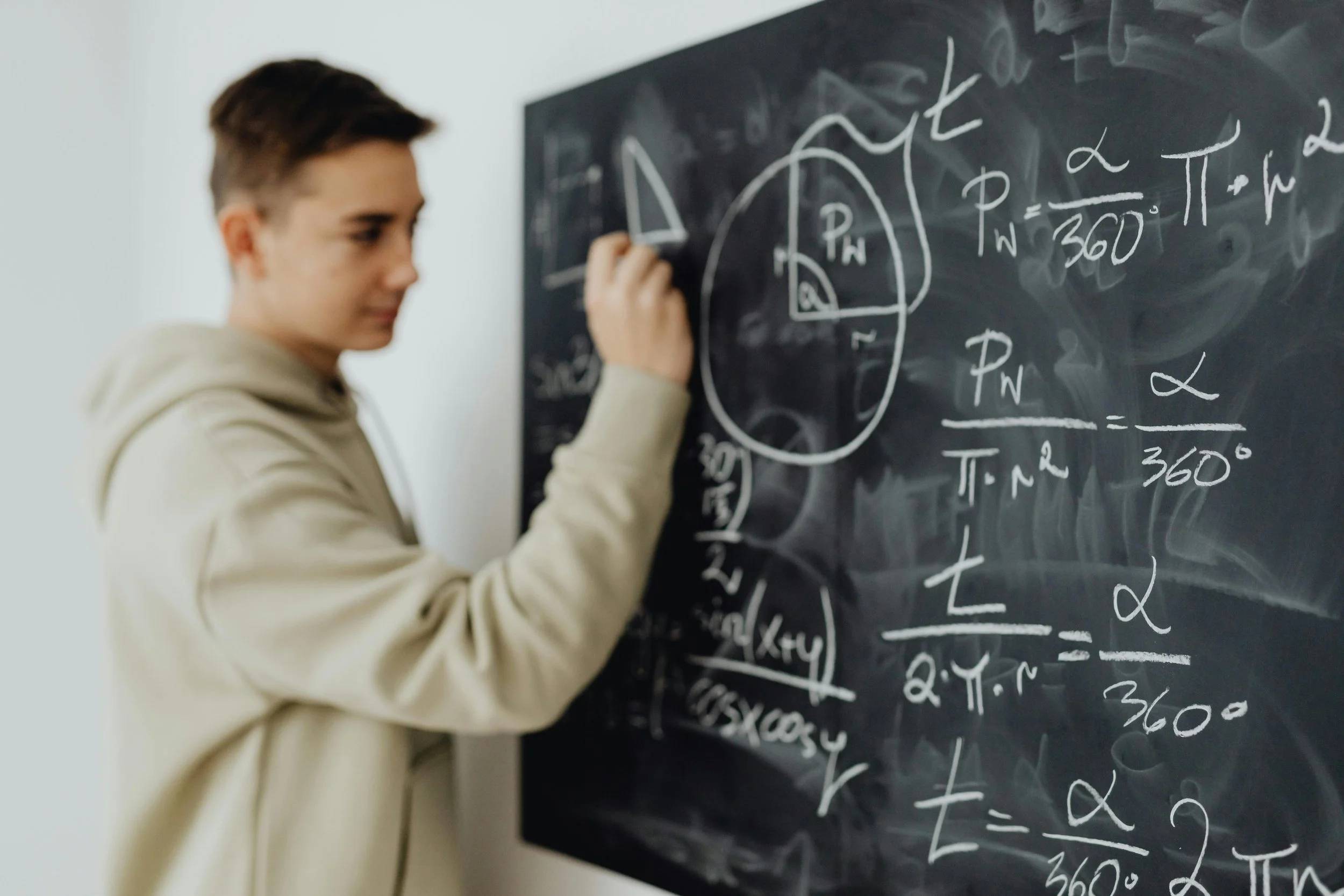 Student writing math on a chalkboard for Purpose Tutoring article about explaining the why